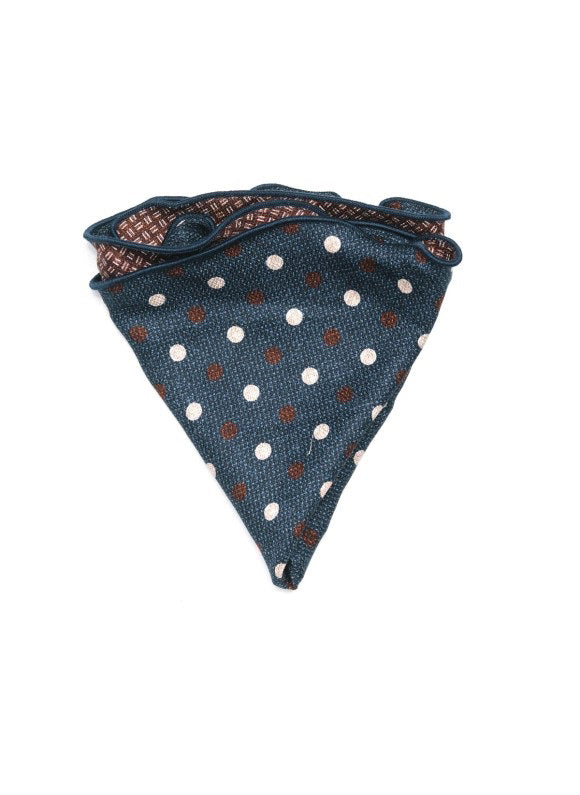 The EDWARD ARMAH - SILK REVERSIBLE POCKET CIRCLE NAVY DOTS by EDWARD ARMAH features a blue triangular design with white and brown polka dots, a patterned brown edge, and denim-like accents, shown on a white background.