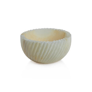 The SPIRALED ONYX SERVING BOWL by ZODAX features a round, off-white design with a grooved exterior and is crafted from elegant Onyx Marble, shown against a white background.