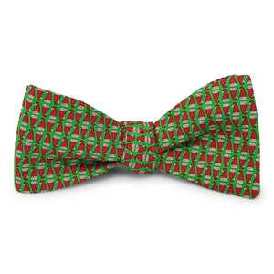 A green silk bow tie with a repeating pattern of red and white Santa hats, handmade in North Carolina by Bird Dog Bay, featuring adjustable neck sizing. The style is the Peter-Blair - Santa Hats Silk Bow Tie in Green.