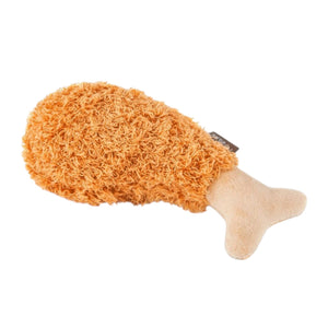 The AMERICAN CLASSIC FRIED CHICKEN dog toy by PLAY PET LIFESTYLES/BRANDS is a plush toy shaped like a fried chicken drumstick, featuring a textured orange-brown “meat” section and a smooth beige “bone” end.