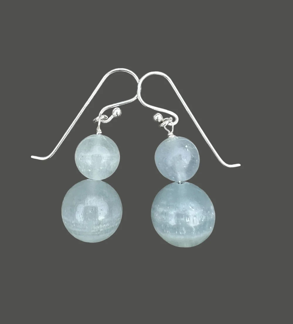 ANN LIGHTFOOT DOUBLE DROP BLUE CALCITE EARRINGS: Two round, translucent light blue calcite beads stacked vertically on each sterling silver hook, shown against a white background.