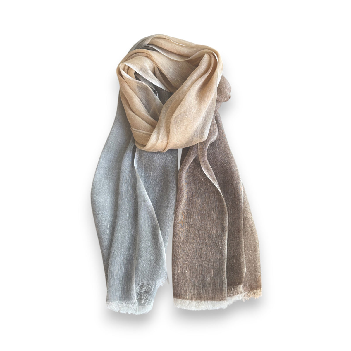 The BAJRA Hand Dyed Linen Blend Scarf in Heather Ombre is a lightweight, handmade piece with a gradient of beige, gray, and brown hues. It features Nepalese design elements such as delicate texture and frayed edges, elegantly showcased on a white background.