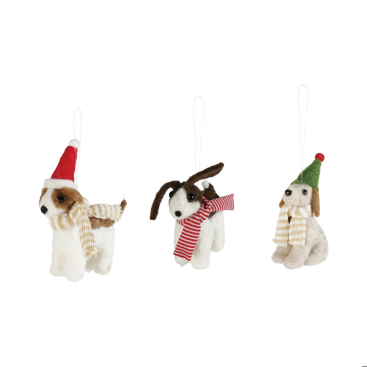 Three handcrafted FELT DOG ORNAMENT holiday decorations wearing festive hats and scarves perched atop a red plaid gift box.