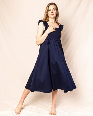 A sleeveless, navy blue Petite Plume - Twill Margaux Smocking Night Dress with a smocked bodice and ruffled straps. The long, flowing skirt creates an elegant silhouette suitable for casual or formal occasions, evoking the timeless charm of the French Riviera.