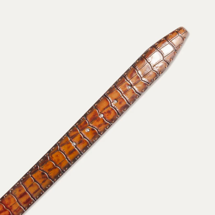 The WILL LEATHER GOODS - CROCO BELT IN COGNAC features Italian leather with a crocodile pattern and a silver buckle, shown coiled loosely on a light background.
