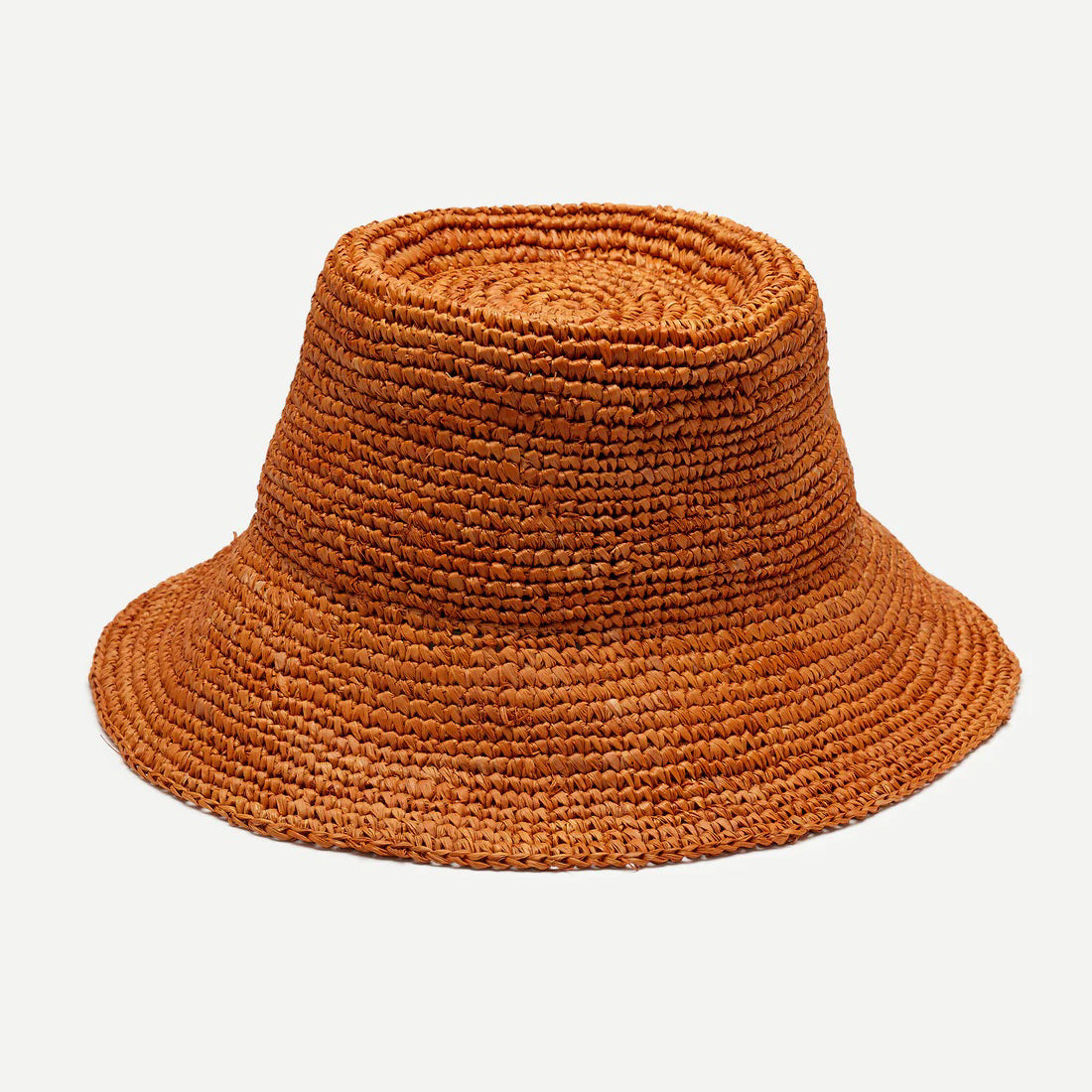 The WYETH HATS - THE TALI is a brown hand-crocheted raffia straw hat featuring a wide brim, showcased against a plain white background.