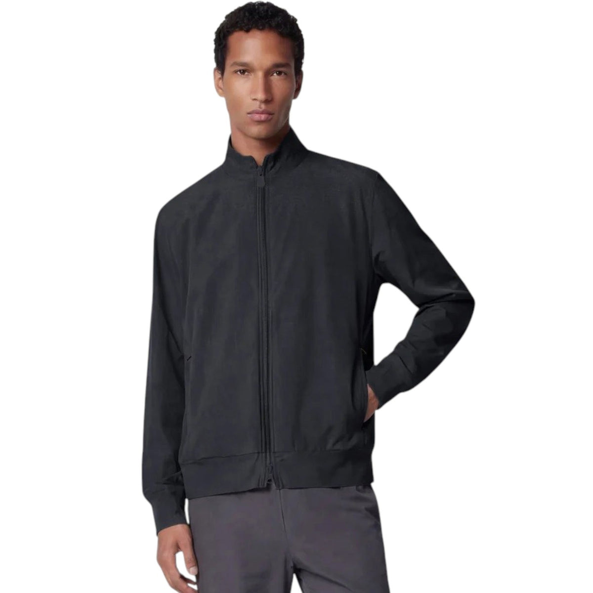 A person stands facing forward, wearing the SAVE THE DUCK - TULIO JACKET IN BLUE BLACK by SAVE THE DUCK, paired with gray pants and white sneakers, against a plain light background.