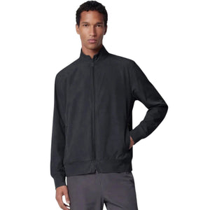 A person stands facing forward, wearing the SAVE THE DUCK - TULIO JACKET IN BLUE BLACK by SAVE THE DUCK, paired with gray pants and white sneakers, against a plain light background.