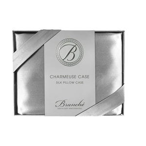 The BRANCHE - CHARMEUSE PILLOW CASE SILK comes boxed with a gray label and pink ribbon, stating “BRANCHE Sleep Luxury. Wake Up Beautiful.” Designed to reduce hair frizz and prevent wrinkles.