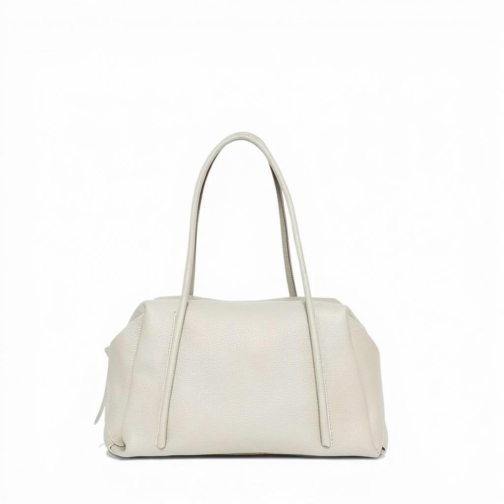 The OLIVEVE Solara Satchel, crafted from lamb Italian buffalo cowhide leather in a light beige shade, features two long handles and a top zipper closure. Made in the USA, it is showcased against a plain white background.