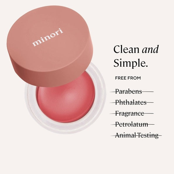 An open jar of MINORI - CREAM BLUSH in the shade Sweet Pea, featuring a pink lid and revealing a smooth, rosy pink cream-to-powder formula inside the clear container for a natural-looking blush finish.
