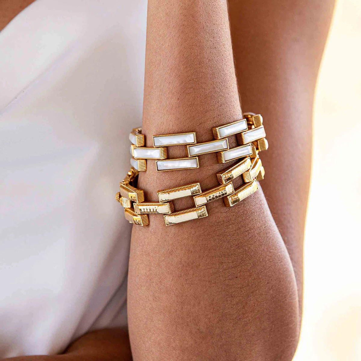 A close-up view of the CAPUCINE DE WULF - PATHWAY LINK BRACELET, GOLD showcases its handcrafted rectangular, textured links connected in a bold geometric pattern. This 18K gold bracelet features a shiny finish and clasp closure from the esteemed brand, CAPUCINE DE WULF.