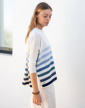 Woman wearing the MERSEA - CATALINA CREWNECK SWEATER, white with two black stripes, paired with denim shorts and a gold necklace—an essential piece from MERSEA for effortless, versatile style.