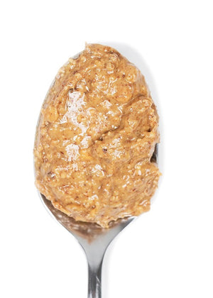 A jar of BIG SPOON ROASTERS - FIJI GINGER ALMOND, featuring a gold lid and a white label with pink accents that displays the brand name, flavor, and additional product information. The crystallized ginger-infused almond butter is visible through the clear jar.