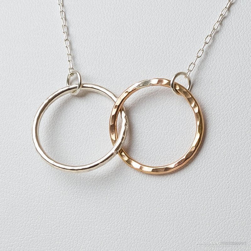 A close-up of KENDA KIST - THE BFF NECKLACE by KENDA KIST, a stunning two-tone interlocking circle necklace, perfect for celebrating friendship.