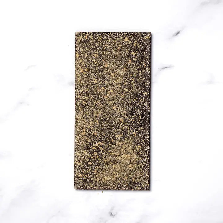 A RITUAL CHOCOLATE - SMORES CHOCOLATE BAR 70% by RITUAL CHOCOLATE, in brown with gold geometric accents and "Graham Cracker and Caramelized Sugar, 70% Cacao" on the label, evokes classic campfire s’mores in every bite.