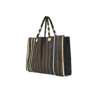 The GABRIELE FRANTZEN Little Sister Weekender Bag in Nomad features a spacious rectangular design with two handles and black, brown, and beige vertical stripes on white—ideal for stylish weekend getaways.