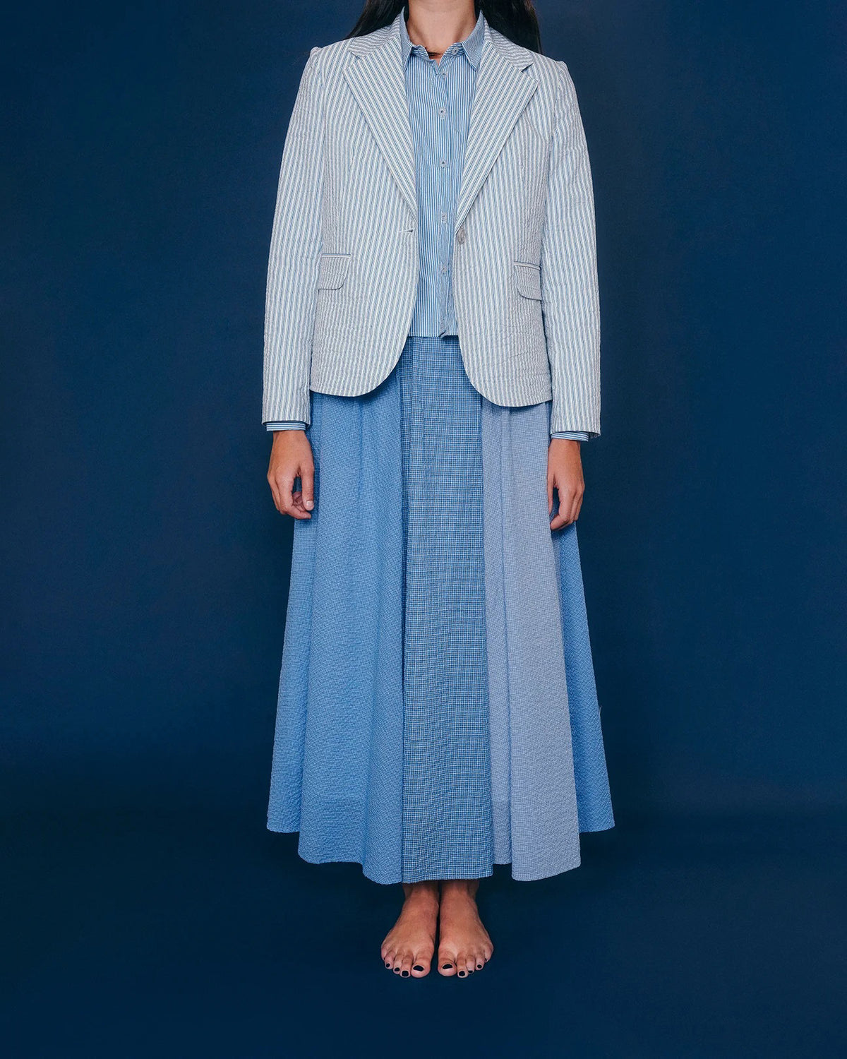 The Little Project&#39;s Georgia Blazer in Puckered Stripes offers a tailored fit with blue and white pinstripes, notched lapel, single-button closure, two front pockets, full lining, and a visible care label inside the neck.