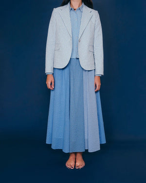 The Little Project's Georgia Blazer in Puckered Stripes offers a tailored fit with blue and white pinstripes, notched lapel, single-button closure, two front pockets, full lining, and a visible care label inside the neck.