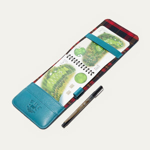 The WILL LEATHER GOODS - GOLF YARDAGE BOOK IN TURQUOISE is a full-grain leather cover, partially open to display notebook pages and cards—ideal for organizing your golf scorecard or yardage book.
