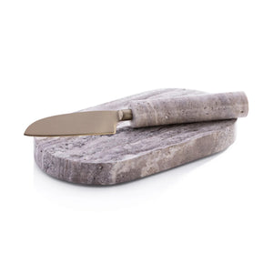 The ZODAX TRAVERTINE MARBLE CUTTING BOARD AND KNIFE set features a metal knife with a stone handle and an oval, marbled gray travertine board, both elegantly displayed against a white background.