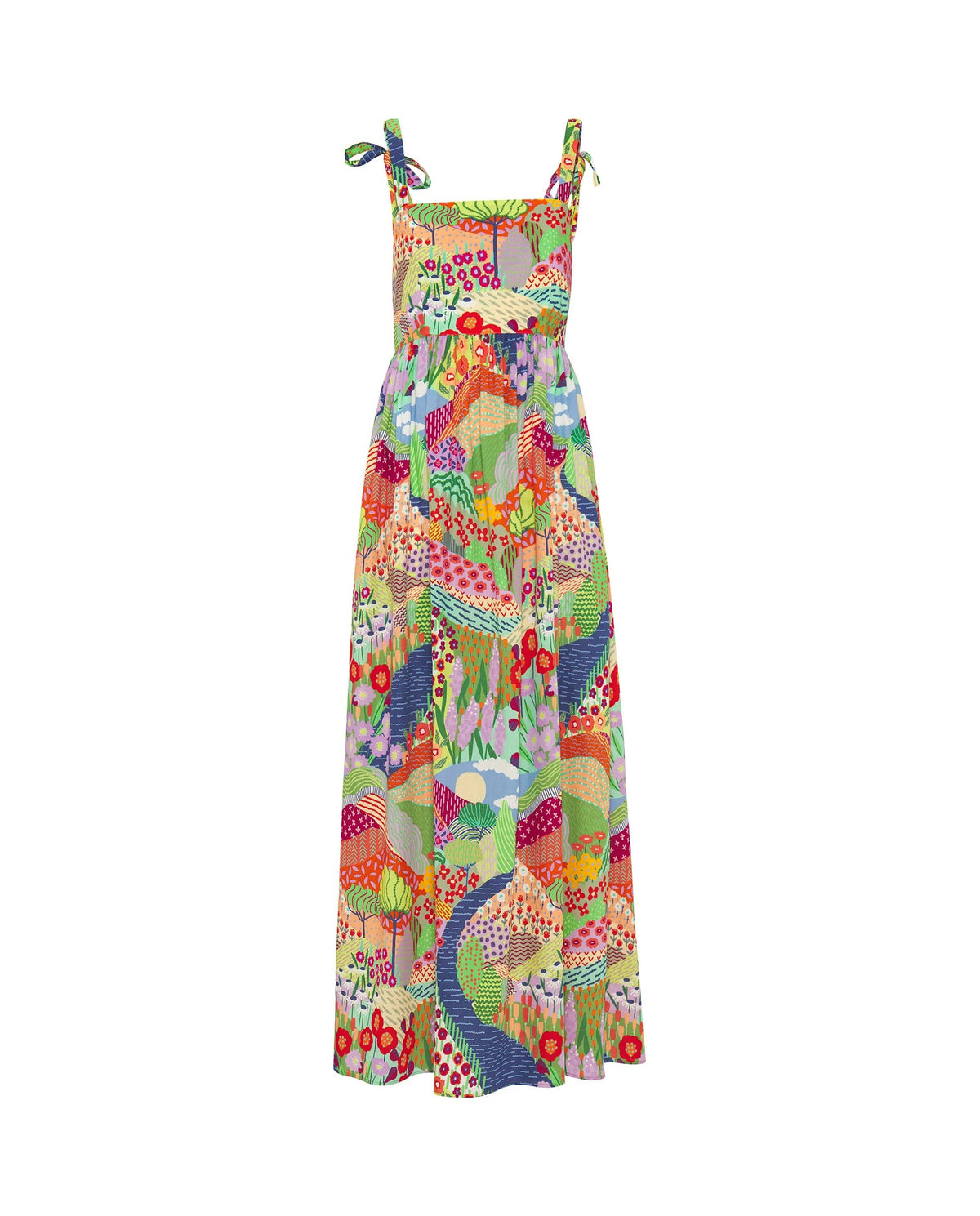 A woman with straight blond hair wears the MIRTO 1956 Multicolor Print Maxi Dress with vibrant patchwork and shoulder ties, paired with red open-toe heels, standing against a plain white background.