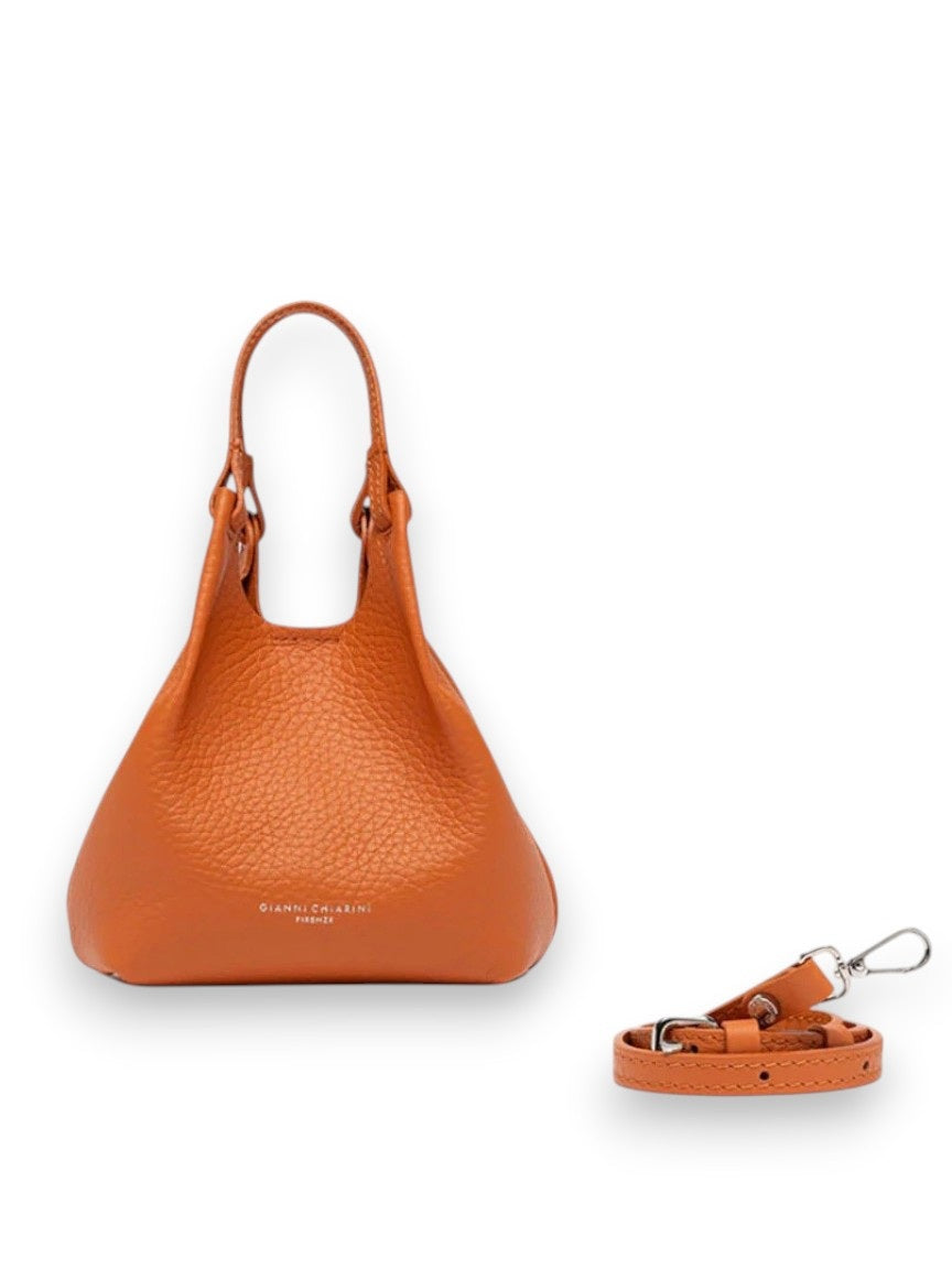The GIANNI CHIARINI MINI DUA BAG IN SPICE, a small textured orange leather bag with double handles, is shown on a white background alongside its matching detachable crossbody strap with silver clasp.