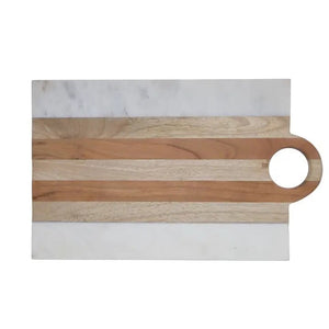 A kitchen scene with three BE HOME - MOA MARBLE & WOOD RECTANGULAR BOARDs by BE HOME, INC, paired with wine, herbs, lemon, cherry tomatoes, bread, olive oil, and spices on a beige surface—highlighting handcrafted home goods.