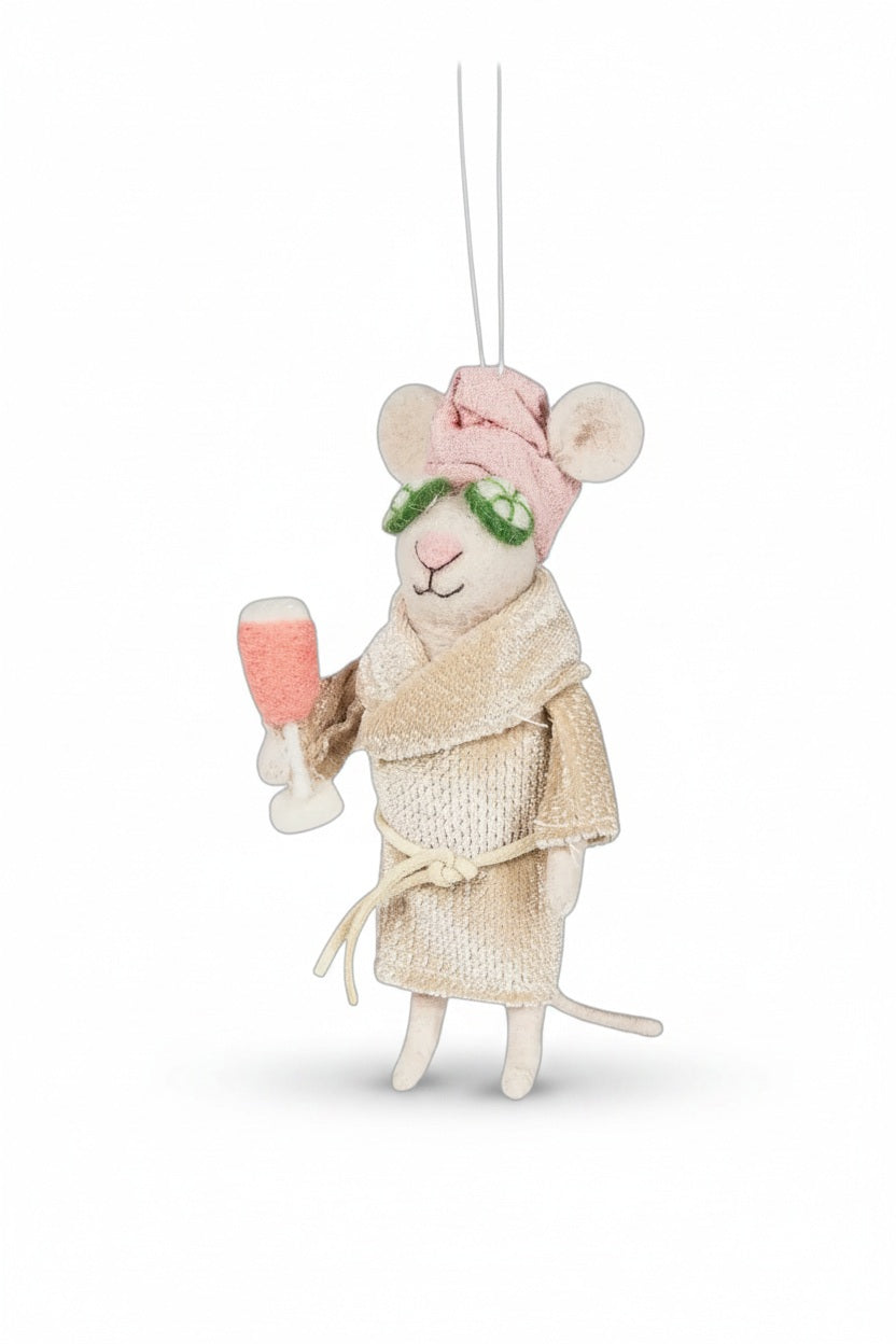 An ABBOTT SPA MOUSE WITH CUCUMBERS ONAMENT made of felt, wearing a bathrobe, a pink towel on its head, and cucumber slices over its eyes, holding a pink drink.