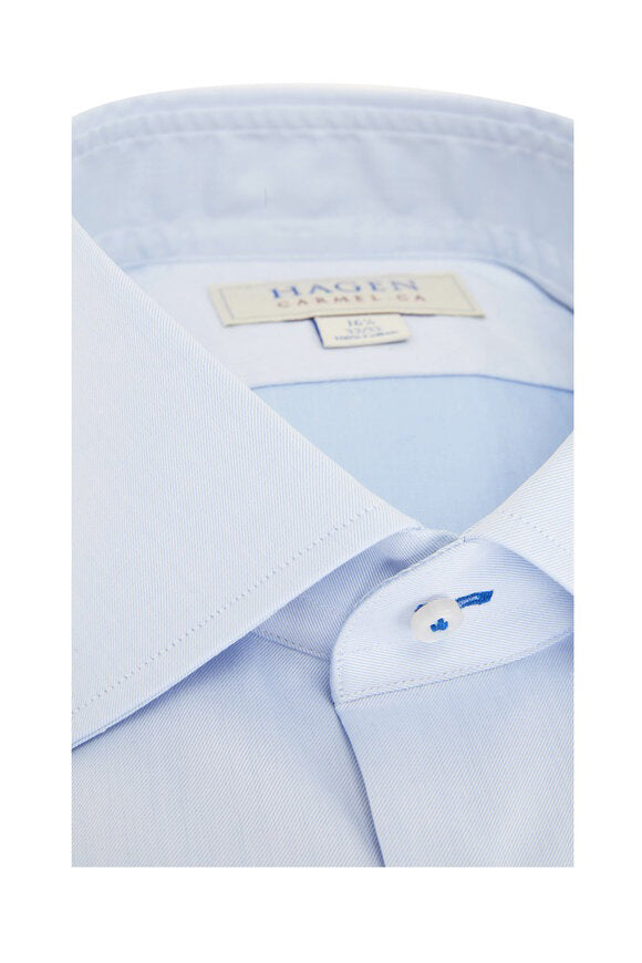 The HAGEN - COTTON DRESS SHIRT IN LIGHT BLUE is neatly folded, featuring a modern spread collar, white buttons, and premium cotton. The label inside the collar displays "Hagen Carmel, CA" with size details.