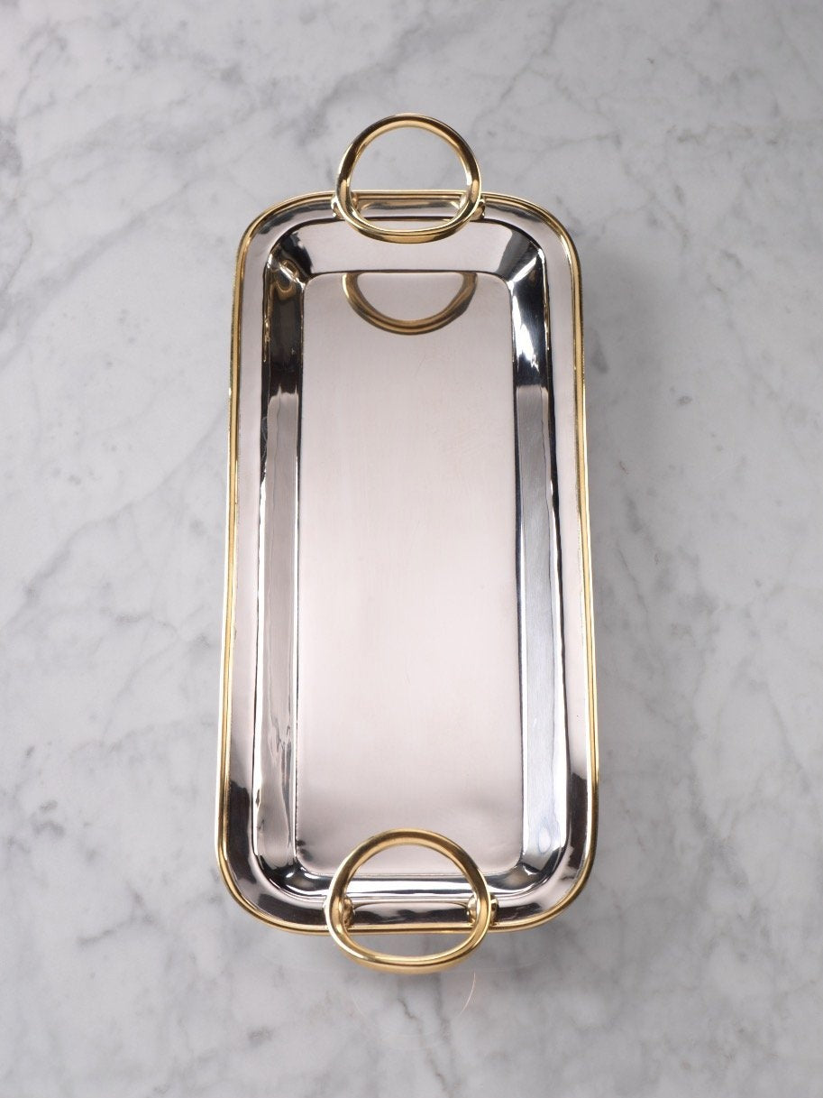 The ZODAX POLISHED NICKEL AND GOLD TRAY showcases a rectangular silhouette in polished nickel, elegantly accented with gold trim and two large gold handles at each end, displayed from an overhead view against a white background.