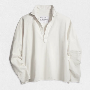 The FRANK & EILEEN Patrick Popover Henley in Heritage Jersey White, a relaxed-fit long-sleeve shirt with an open neckline, is shown laid flat on a textured white surface. The tag displays the FRANK & EILEEN brand name.