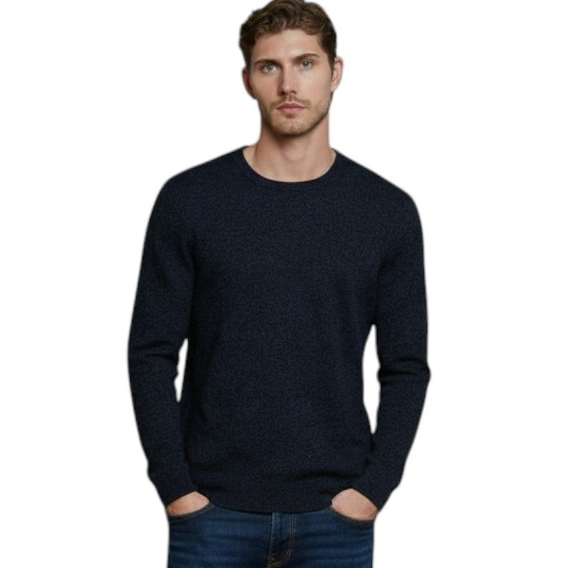 A man with short brown hair stands with his hands in his pockets against a white background, wearing the AUTUMN CASHMERE - Cashmere Basic Crew Neck with Rib Bottom in Midnight and blue jeans.