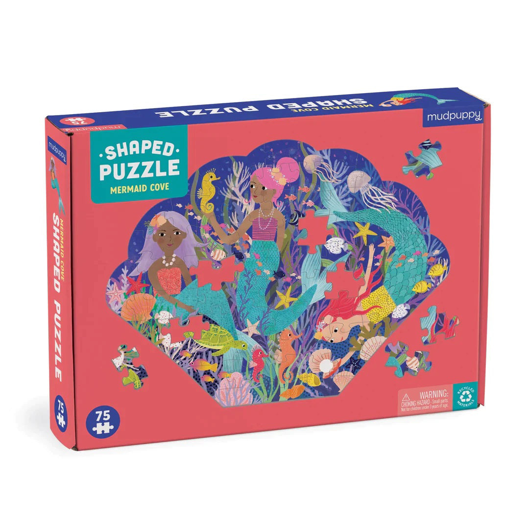 The image depicts the box of a seashell-shaped puzzle titled "Mermaid Cove Puzzle" by Petit Collage. The box features vibrant illustrations of mermaids and underwater scenery, including various sea creatures and plants. This 75+ piece recycled paper puzzle is designed for ages 4 and up.