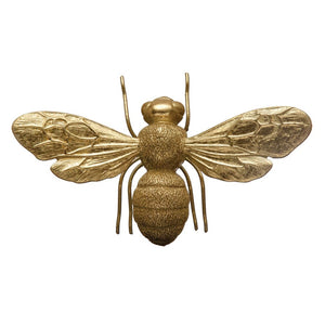 The RESIN BEE by CREATIVE COOP is a metallic, gold-colored decorative bee figurine featuring detailed wings, antennae, and body texture. Viewed from above, its intricate design captures the bee's natural segments and wing patterns, making it a realistic yet stylized unique display-worthy piece.