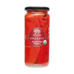 A clear glass jar of DIVINA Roasted Red Peppers features a black lid and a red label, displaying whole roasted peppers inside. The label highlights that these flavorful organic peppers are USDA Organic certified and shelf-stable for convenient storage.