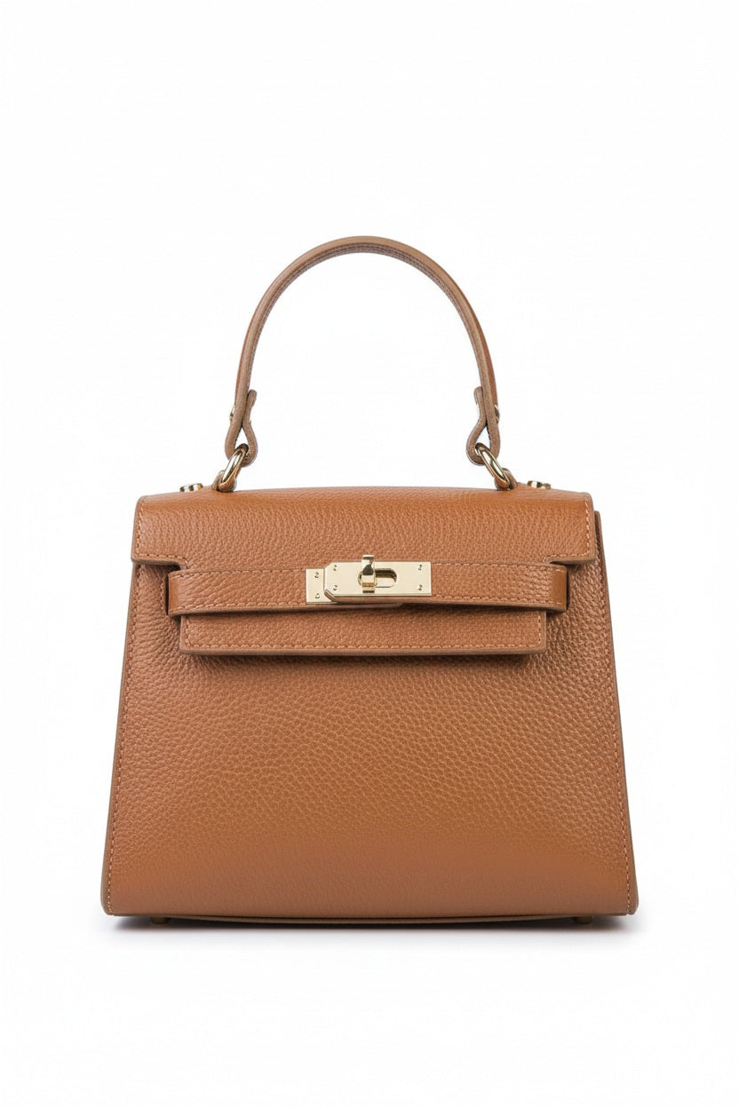 The LE BORSETTE LEATHER SATCHEL BAG is a small, structured satchel-shaped handbag in light pink, featuring a gold clasp at the front. It boasts a single top handle, an adjustable shoulder strap, and two gold-tone hardware pieces on either side of the handle. The textured leather adds to its luxurious and elegant appearance against the plain white background.