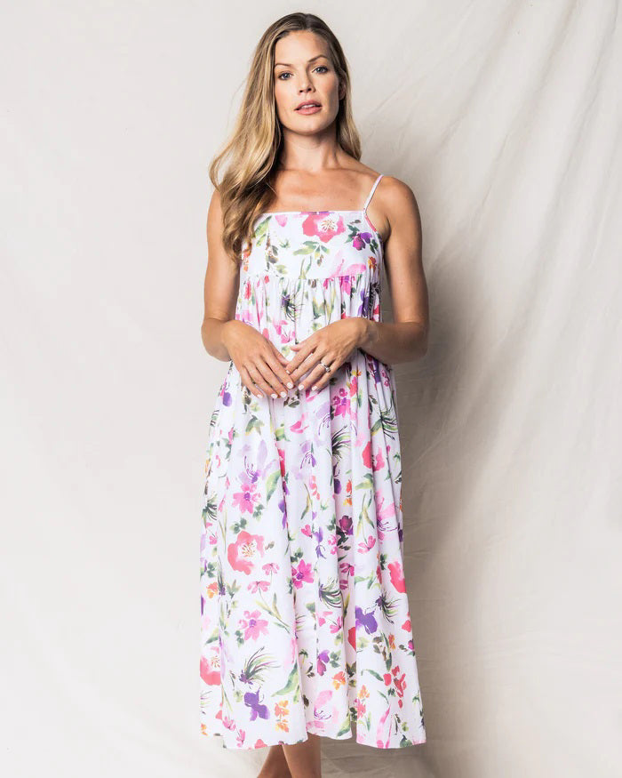 Introducing the PETITE PLUME - GARDENS OF GIVERNY SERENE NIGHTGOWN by PETITE PLUME. This sleeveless, ankle-length summer dress boasts thin spaghetti straps and a fitted bodice, expertly crafted from the finest quality cotton. It showcases vibrant hazy florals in shades of pink, purple, green, and orange on a pristine white background.
