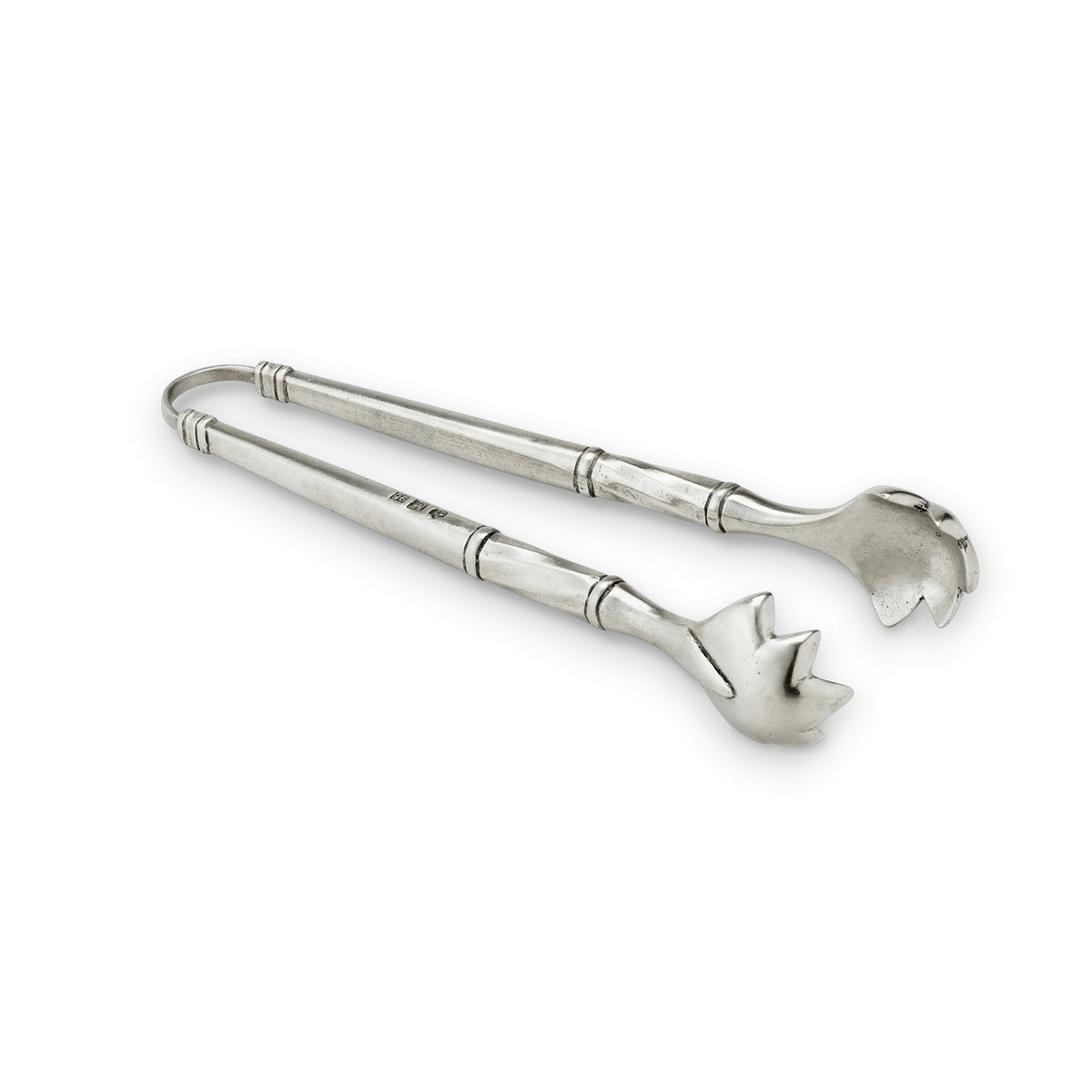 A bundle of fresh asparagus in a white rectangular dish with metal handles sits beside a folded green napkin and MATCH - PEWTER TONGS by MATCH, all displayed on a patterned gray surface.