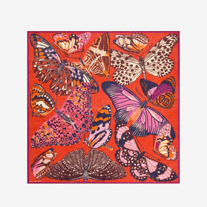 The INOUI EDITIONS PAPILLONS Square Wool Scarf in red features colorful butterflies in pink, orange, purple, and brown across a vibrant 130x130cm design—an eye-catching and versatile accessory for any occasion.