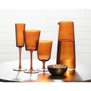 Three amber-colored swirl optic glass stemware pieces and a matching Abbott OPTIC SWIRL CARAFE arranged on a table with a small bowl of nuts.