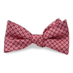 A vibrant red PETER-BLAIR Hot Air Balloons Silk Bow Tie by BIRD DOG BAY, featuring a charming repeating pattern of small, light pink ovals outlined in blue, is handmade in North Carolina and displayed against a crisp white background.