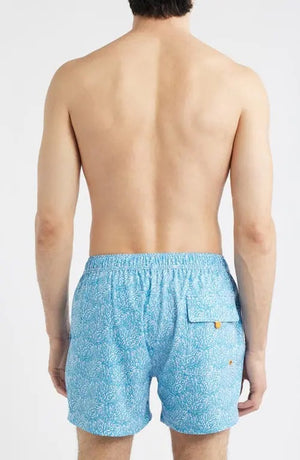 A shirtless man wears SAVE THE DUCK - ADEMIR swim trunks in light blue corals NO FISHING, made from quick-dry recycled polyester with a black drawstring, standing against a plain white background.