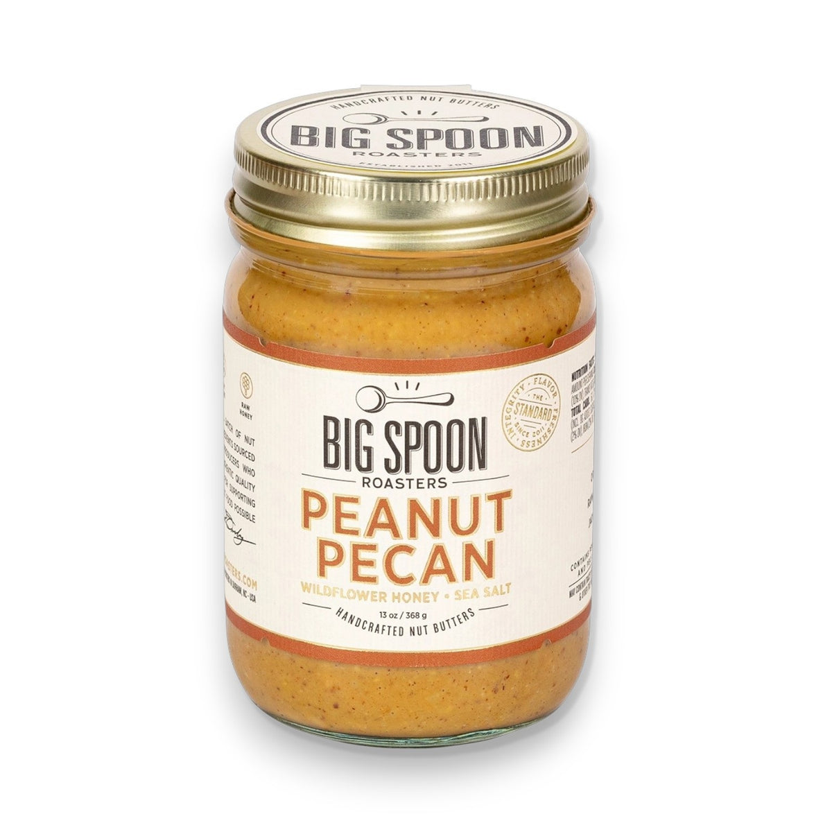 A jar of BIG SPOON ROASTERS - PECAN PEANUT WILDFLOWER HONEY NUT BUTTER features wildflower honey, organic coconut oil, and sea salt. The gold lid and white label display the BIG SPOON ROASTERS brand and product details.