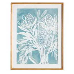 A framed protea abstract print in soft blue by NAPA HOME AND GARDEN, featuring a white floral illustration on a blue background. This botanical wall art is presented in a light wood frame for a fresh, contemporary look—perfect for modern home décor.