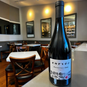 A dark wine bottle with a black cap. The white label reads “CORVEE PASSOCROCE LAGREIN 2020” and features a minimalist stone pattern with one stone colored red, reflecting the unique character of this mountain red wine from Val di Cembra, crafted by WINE: 3 KEYS.