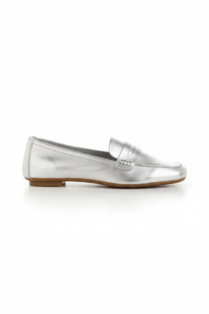 The REQINS HEMA Metallic Loafer in Silver is photographed from above on a light background, revealing its shimmering leather and the brand’s name visible on the dark insole.