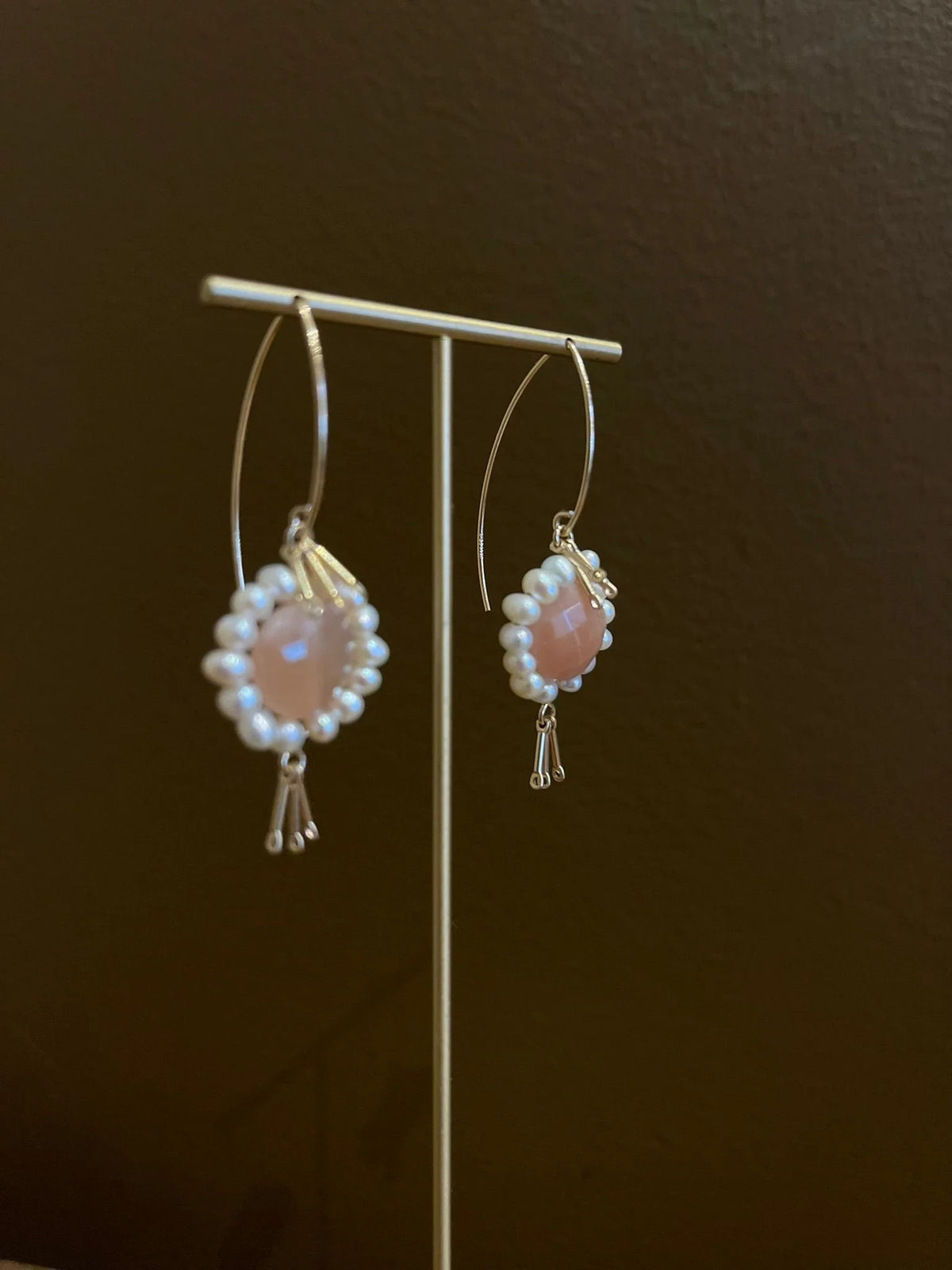 GOLDISH - Floral Gemstone Earrings in Pink Moonstone and White Pearl feature delicate 14K gold fill fringe beneath pink moonstones and white pearls, displayed on a white stand for an elegant look.