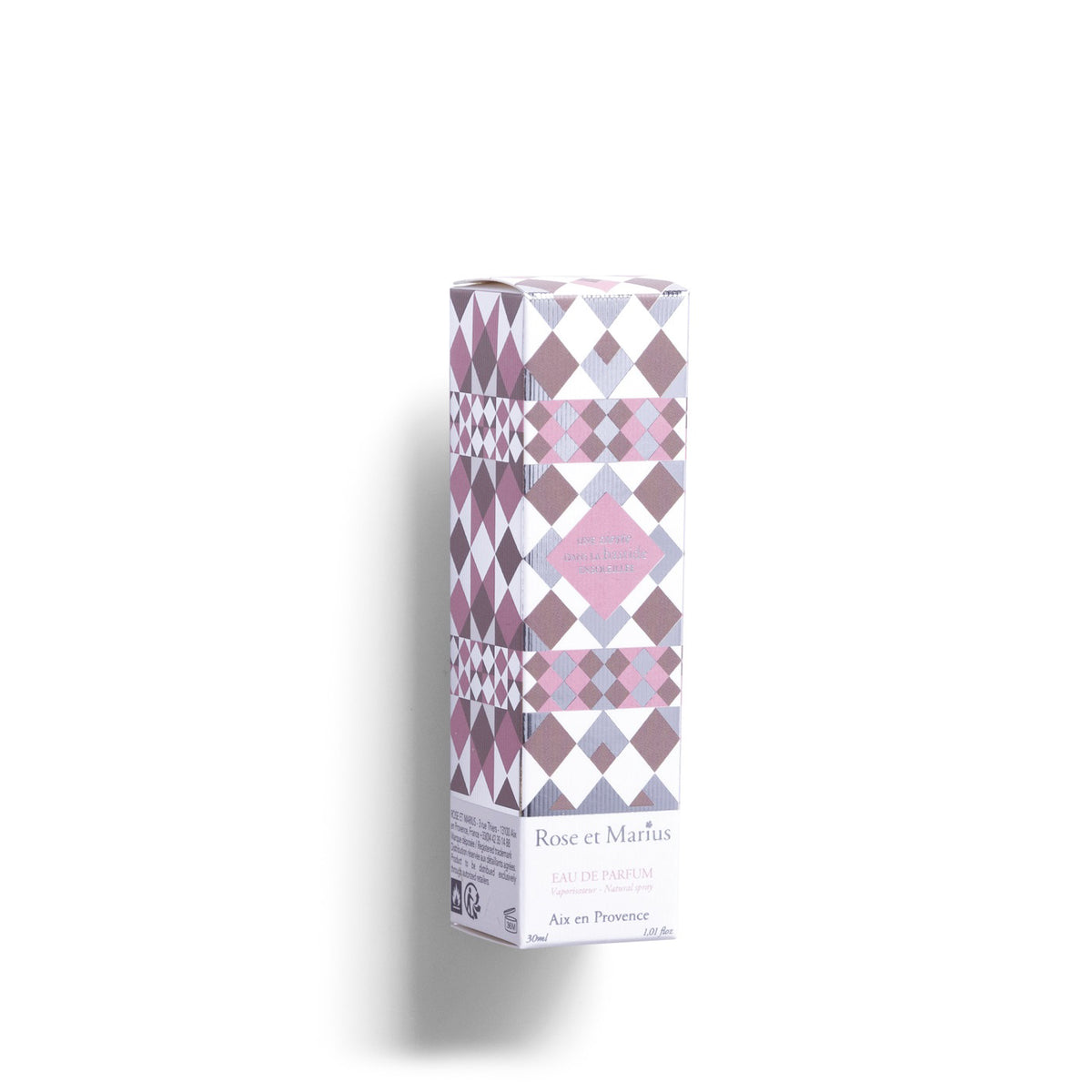 A rectangular glass perfume bottle with a silver spray nozzle and square cap beside it casts a shadow on white. The label reads &quot;ROSE ET MARIUS - A SIESTA IN A SUNLIT HOME EAU DE PARFUM 30ML,&quot; evoking the scent of Provence.