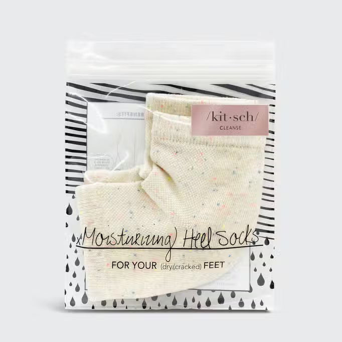 Displayed against a plain background are two light beige KITSCH - MOISTURIZING HEEL SOCKS with subtle multicolored speckles. They feature an insulated gel lining, positioned side by side to show their knit texture, promising to hydrate and soften your skin.